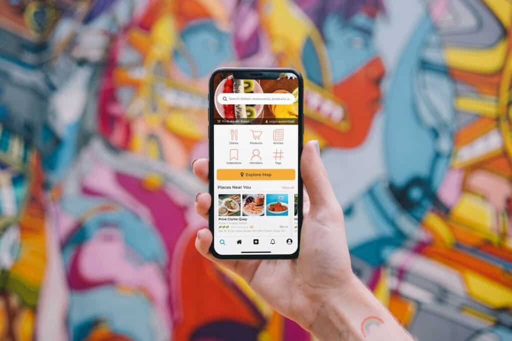 An iPhone shows a mobile app that follows ASO guidelines with a colorful painted wall in the background.
